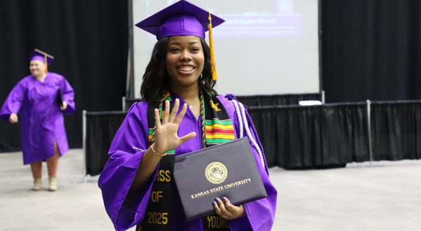 A K-State Salina student holds her diploma during a commencement ceremony.