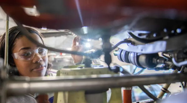 Student inspecting airplane engine