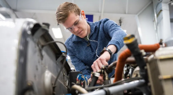 student working on airplane engine