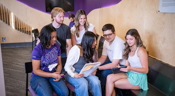 A group of students gather inside of a building on the K-State Salina campus and enjoy hanging out with one another.