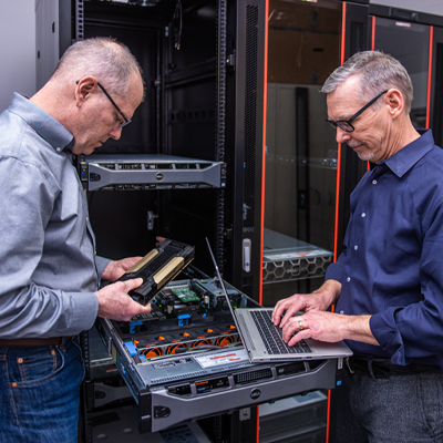 Professionals in server room with laptop