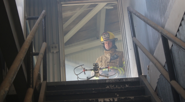 A firefighter operates a drone in a smoky building. K-State's Applied Aviation Research Center provides UAS training for public safety. 