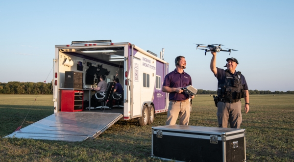 An image of K-State's Applied Aviation Research Center instructor showing a police officer how drone technology can be utilized in a Kansas field.