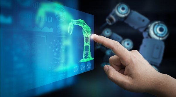 A person designs a piece of equipment utilizing modern technology and a touch screen with a robotic arm in the background.
