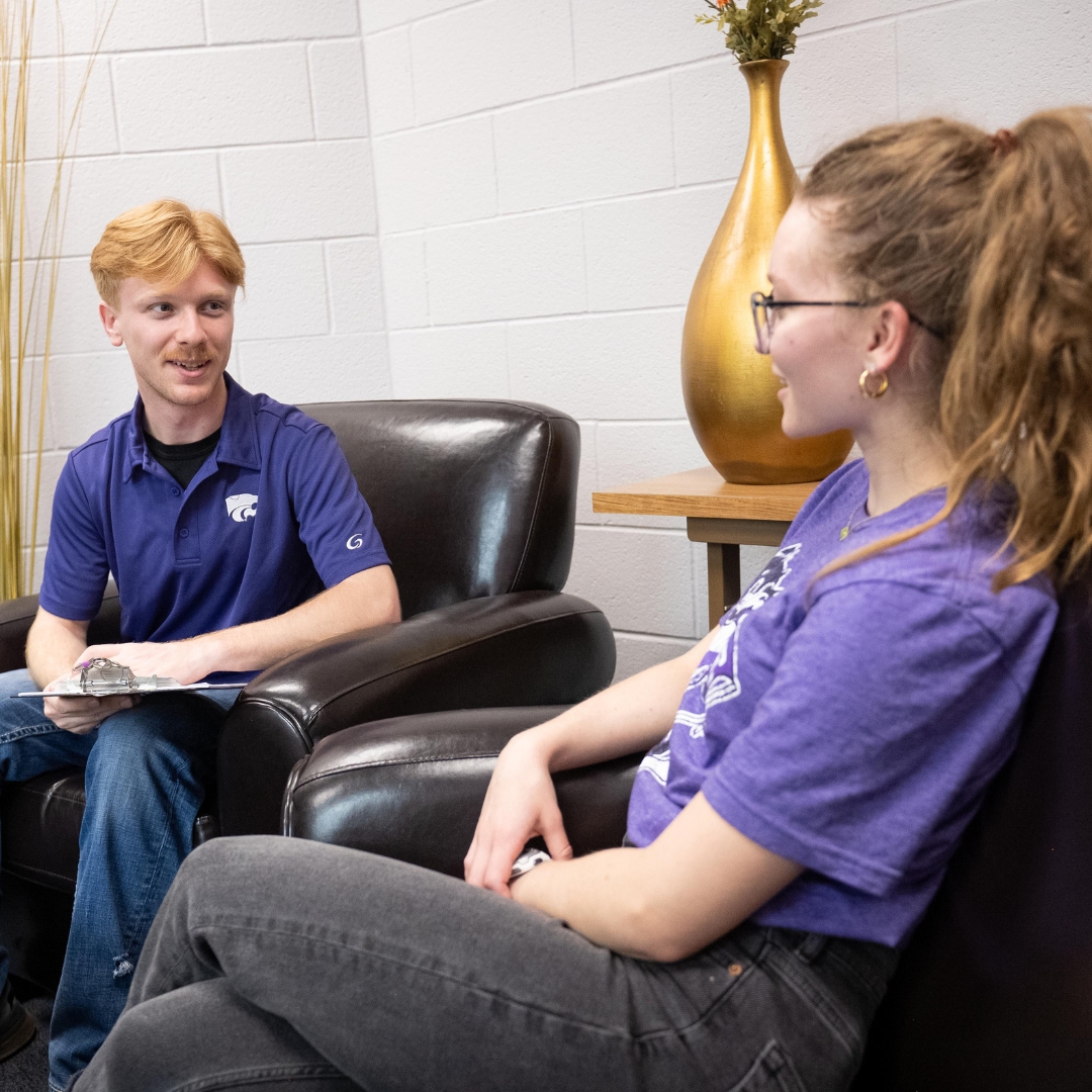 2 students talking in chairs