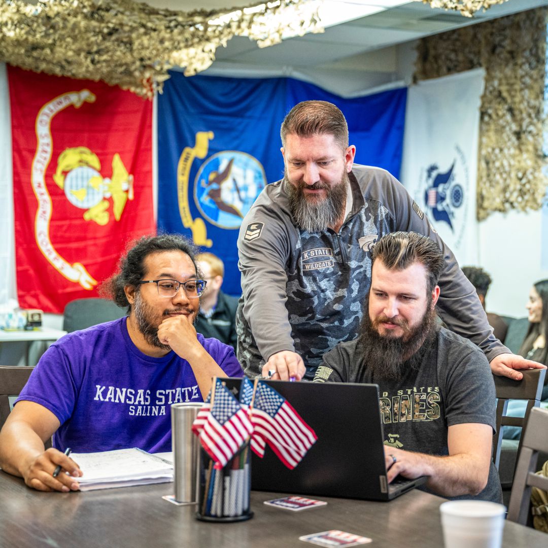 3 student veterans crowded around laptop