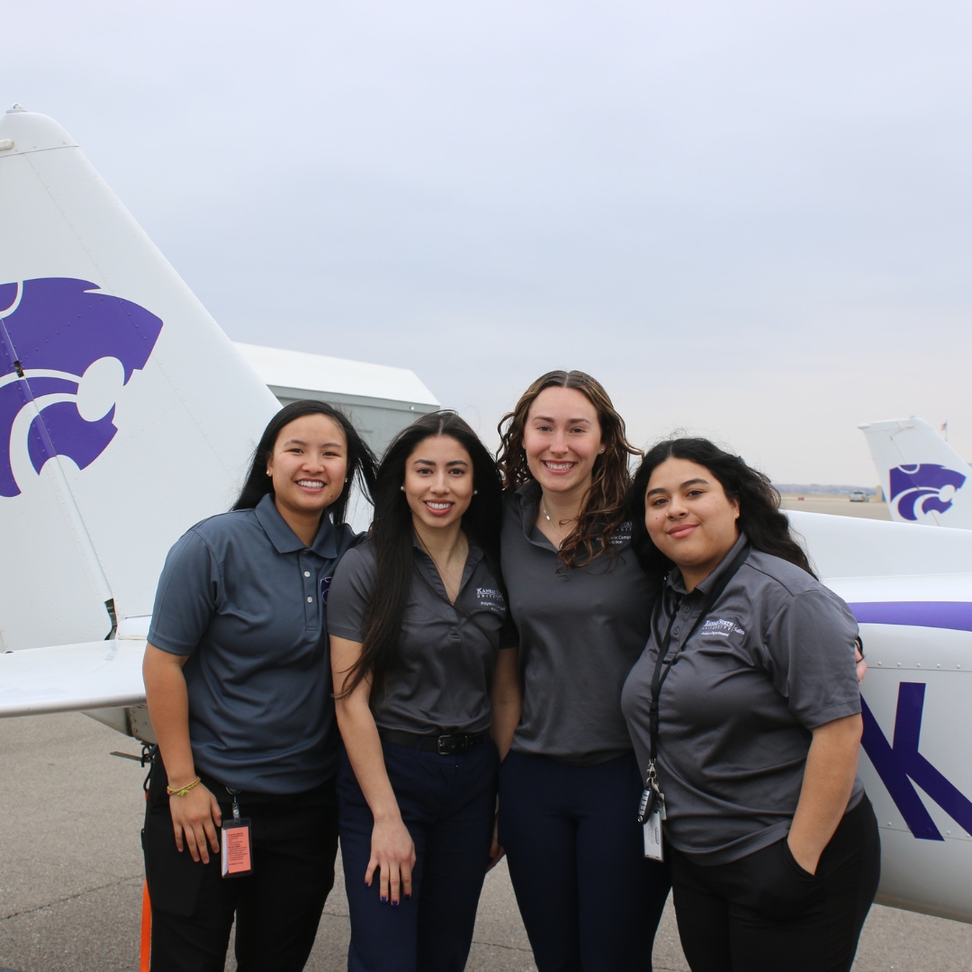 4 female pilots standing beside plane